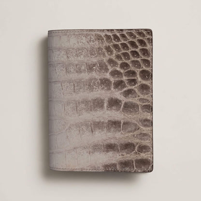 Front view of a closed bespoke passport cover showcasing the natural white-to-grey gradient of matte French Himalayan crocodile leather with hand-painted edges.