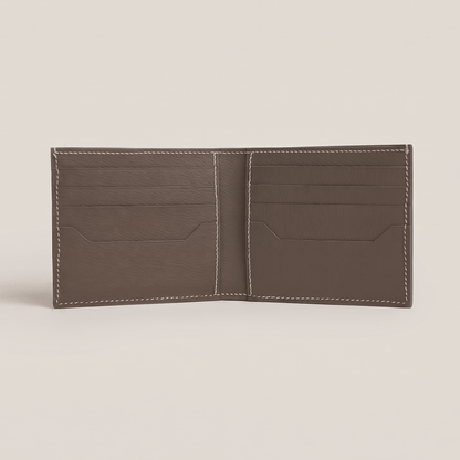 Fully opened interior of the bifold wallet in Étoupe French Alran goatskin, featuring eight card slots, two hidden slip pockets, and white hand stitching.
