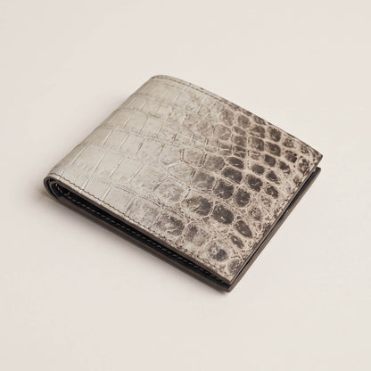 Angled perspective of the closed luxury crocodile bifold wallet, showcasing its slim profile, spine folding curvature, and tactile matte patina.