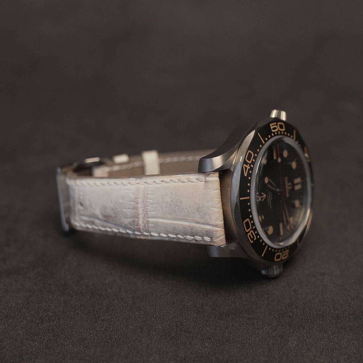 Angled side profile of the Himalayan crocodile watch strap fitted to a luxury timepiece, displaying the tapered padded lug profile and hand-painted edges.