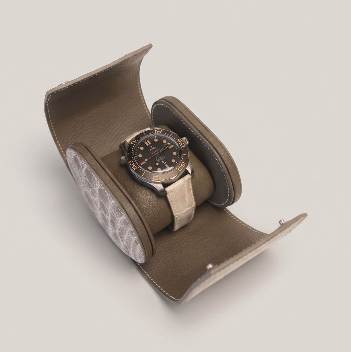 Open Himalayan crocodile travel case with an oversized luxury dive watch mounted on the Étoupe goatskin cushion.
