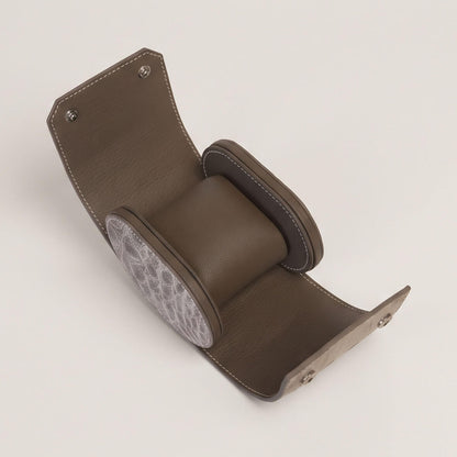 Interior of the open single watch case with an empty Étoupe goatskin cushion secured inside protective side walls.