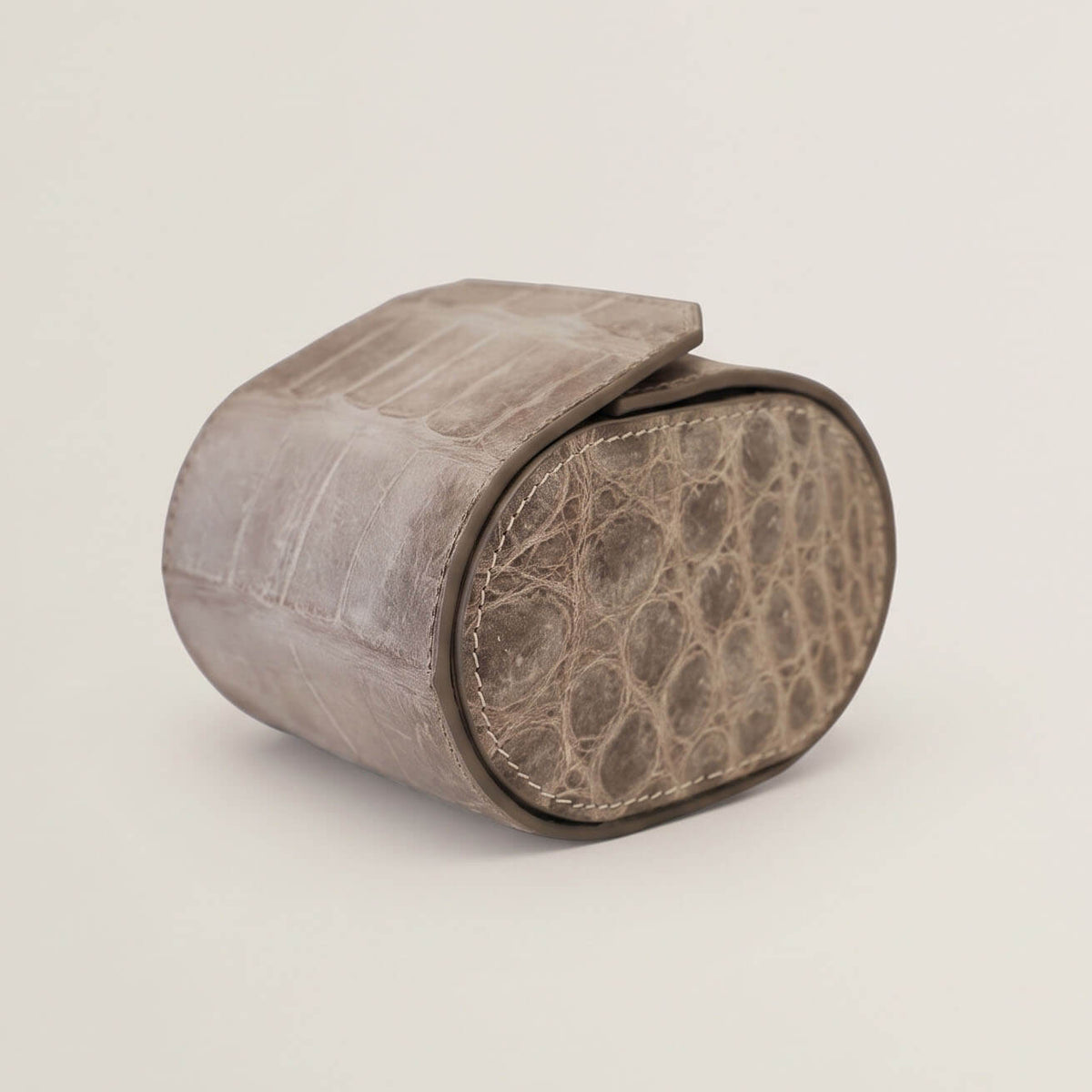 Side profile of the rigid oval watch case displaying hand-burnished edge coating and natural circular crocodile scale patterning.